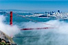 San Franciscos infamous summer fog overtakes the Golden Gate Bridge, viewed from the Marin Headlands with the city of San Francisco visible in the distance. San Francisco, California, USA. Image #09060