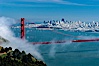 San Franciscos infamous summer fog overtakes the Golden Gate Bridge, viewed from the Marin Headlands with the city of San Francisco visible in the distance. San Francisco, California, USA. Image #09061
