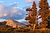 Lembert Dome and late afternoon clouds rise above Tuolumne Meadows in the High Sierra, catching the fading light of sunset. Tuolumne Meadows, Yosemite National Park, California, USA. Image #09938