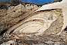 Shale is a fine-grained detrital sedimentary rock formed by the compaction of clay, silt, or mud.  Shale is formed when mud is pressed into rock over millions of years and often breaks into big flat pieces. Here layers of shale emerge from the sand and cliffs at Gaviota State Beach north of Santa Barbara. Gaviota State Beach, Santa Barbara, California, USA. Image #14892