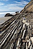 Shale is a fine-grained detrital sedimentary rock formed by the compaction of clay, silt, or mud.  Shale is formed when mud is pressed into rock over millions of years and often breaks into big flat pieces. Here layers of shale emerge from the sand and cliffs at Gaviota State Beach north of Santa Barbara. Gaviota State Beach, Santa Barbara, California, USA. Image #14893