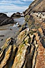 Shale is a fine-grained detrital sedimentary rock formed by the compaction of clay, silt, or mud.  Shale is formed when mud is pressed into rock over millions of years and often breaks into big flat pieces. Here layers of shale emerge from the sand and cliffs at Gaviota State Beach north of Santa Barbara. Gaviota State Beach, Santa Barbara, California, USA. Image #14894