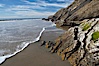 Shale is a fine-grained detrital sedimentary rock formed by the compaction of clay, silt, or mud.  Shale is formed when mud is pressed into rock over millions of years and often breaks into big flat pieces. Here layers of shale emerge from the sand and cliffs at Gaviota State Beach north of Santa Barbara. Gaviota State Beach, Santa Barbara, California, USA. Image #14897