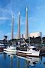 The Morro Bay Power Plant, with its distinctive three stacks, rises above fishing boats in Morro Bay harbor.  Morro Bay. Morro Bay, California, USA. Image #14900