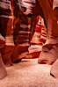 A hiker admiring the striated walls and dramatic light within Antelope Canyon, a deep narrow slot canyon formed by water and wind erosion. Navajo Tribal Lands, Page, Arizona, USA. Image #17994