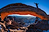 Mesa Arch, Utah.  An exuberant hiker greets the dawning sun from atop Mesa Arch. Island in the Sky, Canyonlands National Park, Utah, USA. Image #18036