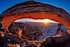 Mesa Arch spans 90 feet and stands at the edge of a mesa precipice thousands of feet above the Colorado River gorge. For a few moments at sunrise the underside of the arch glows dramatically red and orange. Island in the Sky, Canyonlands National Park, Utah, USA. Image #18037