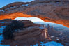 Mesa Arch spans 90 feet and stands at the edge of a mesa precipice thousands of feet above the Colorado River gorge. For a few moments at sunrise the underside of the arch glows dramatically red and orange. Island in the Sky, Canyonlands National Park, Utah, USA
