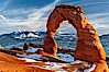 Delicate Arch, dusted with snow, at sunset, with the snow-covered La Sal mountains in the distance.  Delicate Arch stands 45 feet high, with a span of 33 feet, atop of bowl of slickrock sandstone. Delicate Arch, Arches National Park, Utah, Utah, USA. Image #18104