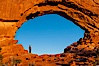 Hiker in North Window, sunset, western face.  North Window is a natural sandstone arch 90 feet wide and 48 feet high. North Window, Arches National Park, Utah, Utah, USA. Image #18160