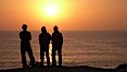 Surf check.  Three guys check the surf from atop a bluff overlooking the waves at the end of the day, at sunset, north of South Carlsbad State Beach. Carlsbad, California, USA. Image #19808