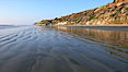 A flat sand beach, sandstone bluffs rise in the background, sunset. Carlsbad, California, USA. Image #19810