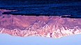 Sunrise lights Telescope Peak as it rises over the salt flats of Badwater, Death Valley.  At 11,049 feet, Telescope Peak is the highest peak in the Panamint Range as well as the highest point in Death Valley National Park.  At 282 feet below sea level, Badwater is the lowest point in North America. Badwater, Death Valley National Park, California, USA. Image #20550
