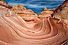 The Wave, an area of fantastic eroded sandstone featuring beautiful swirls, wild colors, countless striations, and bizarre shapes set amidst the dramatic surrounding North Coyote Buttes of Arizona and Utah.  The sandstone formations of the North Coyote Buttes, including the Wave, date from the Jurassic period. Managed by the Bureau of Land Management, the Wave is located in the Paria Canyon-Vermilion Cliffs Wilderness and is accessible on foot by permit only. North Coyote Buttes, Paria Canyon-Vermilion Cliffs Wilderness, Arizona, USA. Image #20605