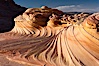 The Second Wave at sunset.  The Second Wave, a curiously-shaped sandstone swirl, takes on rich warm tones and dramatic shadowed textures at sunset.  Set in the North Coyote Buttes of Arizona and Utah, the Second Wave is characterized by striations revealing layers of sedimentary deposits, a visible historical record depicting eons of submarine geology. North Coyote Buttes, Paria Canyon-Vermilion Cliffs Wilderness, Arizona, USA. Image #20606
