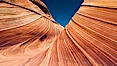 The Wave, an area of fantastic eroded sandstone featuring beautiful swirls, wild colors, countless striations, and bizarre shapes set amidst the dramatic surrounding North Coyote Buttes of Arizona and Utah.  The sandstone formations of the North Coyote Buttes, including the Wave, date from the Jurassic period. Managed by the Bureau of Land Management, the Wave is located in the Paria Canyon-Vermilion Cliffs Wilderness and is accessible on foot by permit only. North Coyote Buttes, Paria Canyon-Vermilion Cliffs Wilderness, Arizona, USA. Image #20608