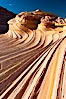 The Second Wave at sunset.  The Second Wave, a curiously-shaped sandstone swirl, takes on rich warm tones and dramatic shadowed textures at sunset.  Set in the North Coyote Buttes of Arizona and Utah, the Second Wave is characterized by striations revealing layers of sedimentary deposits, a visible historical record depicting eons of submarine geology. North Coyote Buttes, Paria Canyon-Vermilion Cliffs Wilderness, Arizona, USA. Image #20613