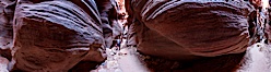 Buckskin Gulch hiker.  A hiker moves through the deep narrow passages of Buckskin Gulch, a slot canyon cut deep into sandstone by years of river-induced erosion.  In some places the Buckskin Gulch narrows are only about 15 feet wide but several hundred feet high, blocking sunlight.  Flash floods are dangerous as there is no escape once into the Buckskin Gulch slot canyons.  This is a panorama made of sixteen individual photos. Buckskin Gulch, Paria Canyon-Vermilion Cliffs Wilderness, Arizona, USA. Image #20699