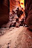 Hiker in Buckskin Gulch.  A hiker considers the towering walls and narrow passageway of Buckskin Gulch, a dramatic slot canyon forged by centuries of erosion through sandstone.  Buckskin Gulch is the worlds longest accessible slot canyon, running from the Paria River toward the Colorado River.  Flash flooding is a serious danger in the narrows where there is no escape. Buckskin Gulch, Paria Canyon-Vermilion Cliffs Wilderness, Arizona, USA. Image #20710