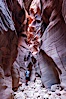 Hiker in Buckskin Gulch.  A hiker considers the towering walls and narrow passageway of Buckskin Gulch, a dramatic slot canyon forged by centuries of erosion through sandstone.  Buckskin Gulch is the worlds longest accessible slot canyon, running from the Paria River toward the Colorado River.  Flash flooding is a serious danger in the narrows where there is no escape. Buckskin Gulch, Paria Canyon-Vermilion Cliffs Wilderness, Arizona, USA. Image #20716