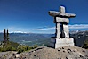 Ilanaaq, the logo of the 2010 Winter Olympics in Vancouver, is formed of stone in the Inukshuk-style of traditional Inuit sculpture.  Located near the Whistler mountain gondola station, overlooking Whistler Village and Green Lake in the distance. Whistler, British Columbia, Canada. Image #21007