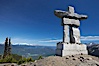 Ilanaaq, the logo of the 2010 Winter Olympics in Vancouver, is formed of stone in the Inukshuk-style of traditional Inuit sculpture.  Located near the Whistler mountain gondola station, overlooking Whistler Village and Green Lake in the distance. Whistler, British Columbia, Canada. Image #21008
