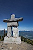 Ilanaaq, the logo of the 2010 Winter Olympics in Vancouver, is formed of stone in the Inukshuk-style of traditional Inuit sculpture.  Located near the Whistler mountain gondola station, overlooking Whistler Village and Green Lake in the distance. Whistler, British Columbia, Canada. Image #21010