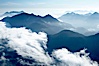 Coastal mountains and clouds, rising above Bedwell Sound (hidden by clouds) and Clayoquot Sound, near Tofino on the west coast of Vancouver Island. Tofino, British Columbia, Canada. Image #21093