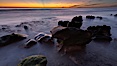 Sunset, sea cliffs, rocks and swirling water blurred in a long time exposure. Carlsbad, California, USA. Image #22198