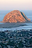 Morro Rock lit at sunrise, rises above Morro Bay which is still in early morning shadow. Morro Bay, California, USA. Image #22218