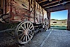 Wagon and interior of County Barn, Brown House and Moyle House in distance. Bodie State Historical Park, California, USA. Image #23106