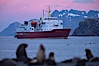 M/V Polar Star, an icebreaker expedition ship, lies at anchor in Right Whale Bay, South Georgia Island.  Antarctic fur seals on the beach, and the rugged South Georgia Island mountains in the distance.  Sunset, dusk. Right Whale Bay, South Georgia Island. Image #24318