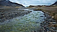 Glacial melt waters, runoff, flows across an alluvial flood plain between mountains, on its way to Stromness Bay. Stromness Harbour, South Georgia Island. Image #24587