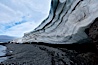 Horizontal striations and layers in packed snow, melting and overhanging, seen from the edge of the snowpack, along a rocky beach. Brown Bluff, Antarctic Peninsula, Antarctica. Image #24782