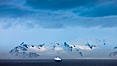 Distant icebergs, mountains, clouds, ocean at dawn, in the South Shetland Islands, near Deception Island. Deception Island, Antarctic Peninsula, Antarctica. Image #25460