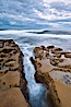 Waves wash over sandstone reef, clouds and sky. La Jolla, California, USA. Image #26336
