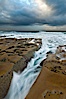 Waves wash over sandstone reef, clouds and sky. La Jolla, California, USA. Image #26338