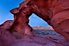 Natural arch formed in sandstone frames the setting moon. Valley of Fire State Park, Nevada, USA. Image #26502