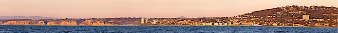 Panorama of La Jolla, with Mount Soledad aglow at sunset, viewed from the Pacific Ocean offshore of San Diego. La Jolla, California, USA. Image #27085