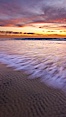 Sunset and incoming surf, gorgeous colors in the sky and on the ocean at dusk, the incoming waves are blurred in this long exposure. Carlsbad, California, USA. Image #27154