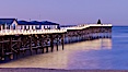 The Crystal Pier and Pacific Ocean at sunrise, dawn, waves blur as they crash upon the sand.  Crystal Pier, 872 feet long and built in 1925, extends out into the Pacific Ocean from the town of Pacific Beach. Pacific Beach, California, USA. Image #27239