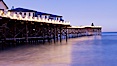 The Crystal Pier and Pacific Ocean at sunrise, dawn, waves blur as they crash upon the sand.  Crystal Pier, 872 feet long and built in 1925, extends out into the Pacific Ocean from the town of Pacific Beach. Pacific Beach, California, USA. Image #27240