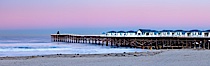 The Crystal Pier and Pacific Ocean at sunrise, dawn, waves blur as they crash upon the sand.  Crystal Pier, 872 feet long and built in 1925, extends out into the Pacific Ocean from the town of Pacific Beach. Pacific Beach, California, USA. Image #27244