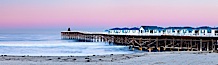 The Crystal Pier and Pacific Ocean at sunrise, dawn, waves blur as they crash upon the sand.  Crystal Pier, 872 feet long and built in 1925, extends out into the Pacific Ocean from the town of Pacific Beach. Pacific Beach, California, USA. Image #27245
