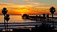 Oceanside Pier at sunset, clouds and palm trees with a brilliant sky at dusk. Oceanside Pier, Oceanside, California, USA. Image #27610