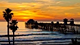 Oceanside Pier at sunset, clouds and palm trees with a brilliant sky at dusk. Oceanside Pier, Oceanside, California, USA. Image #27612