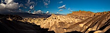Sunrise at Zabriskie Point, Manly Beacon is lit by the morning sun while clouds from a clearing storm pass by. Zabriskie Point, Death Valley National Park, California, USA