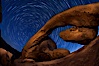 Star trails and Arch Rock. Polaris, the North Star, is at the center of the circular arc star trails as they pass above this natural stone archway in Joshua Tree National Park. Alabama Hills Recreational Area, California, USA. Image #27708