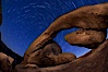 Star trails and Arch Rock. Polaris, the North Star, is at the center of the circular arc star trails as they pass above this natural stone archway in Joshua Tree National Park. Alabama Hills Recreational Area, California, USA. Image #27709