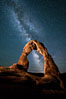 Milky Way arches over Delicate Arch, as stars cover the night sky. Arches National Park, Utah, USA